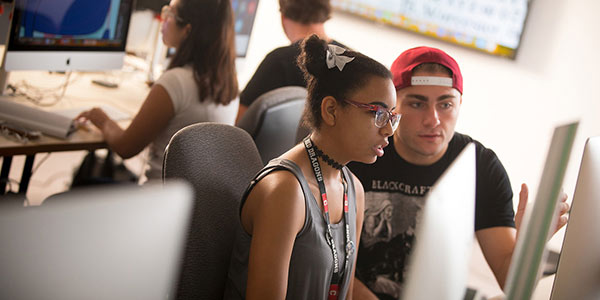 Graphic design and digital media students working at a computer