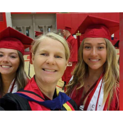 Baert proudly poses with some recent physical education graduates.