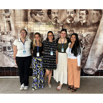 The Cortland cohort gathers beside a Cuban mural
