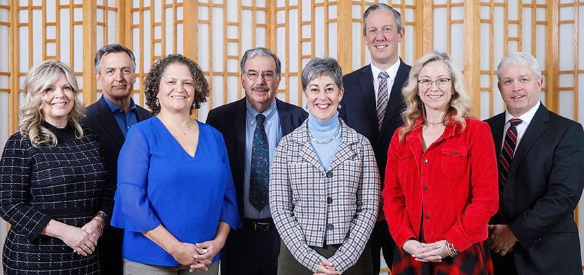 Eight members of President's Cabinet pose for a photo in Spring 2024 semester.