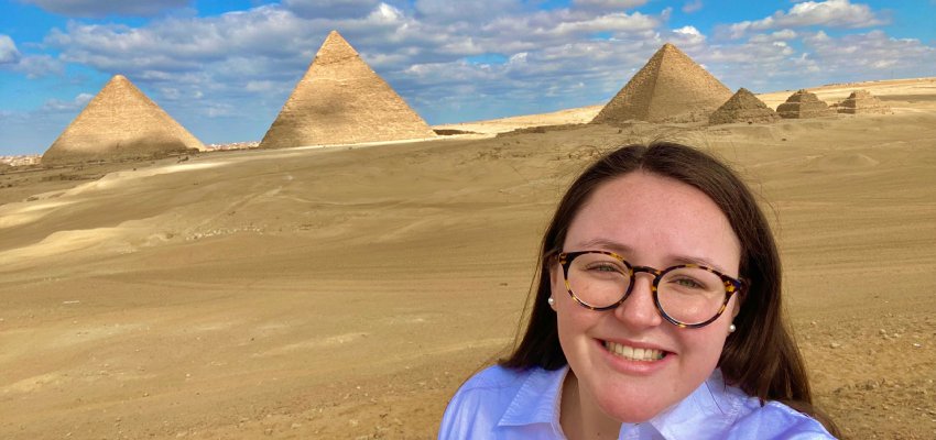 Student standing in Egypt with Pyramids at Giza behind her