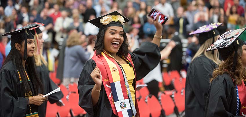 students in regalia, one student wearing international stole