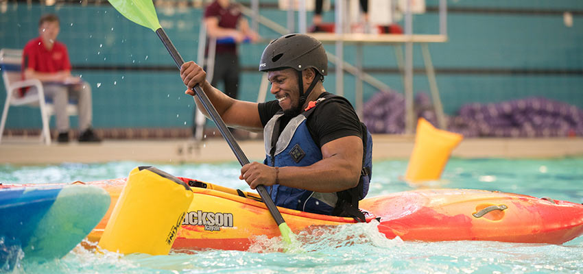 Student kayaking in the pool