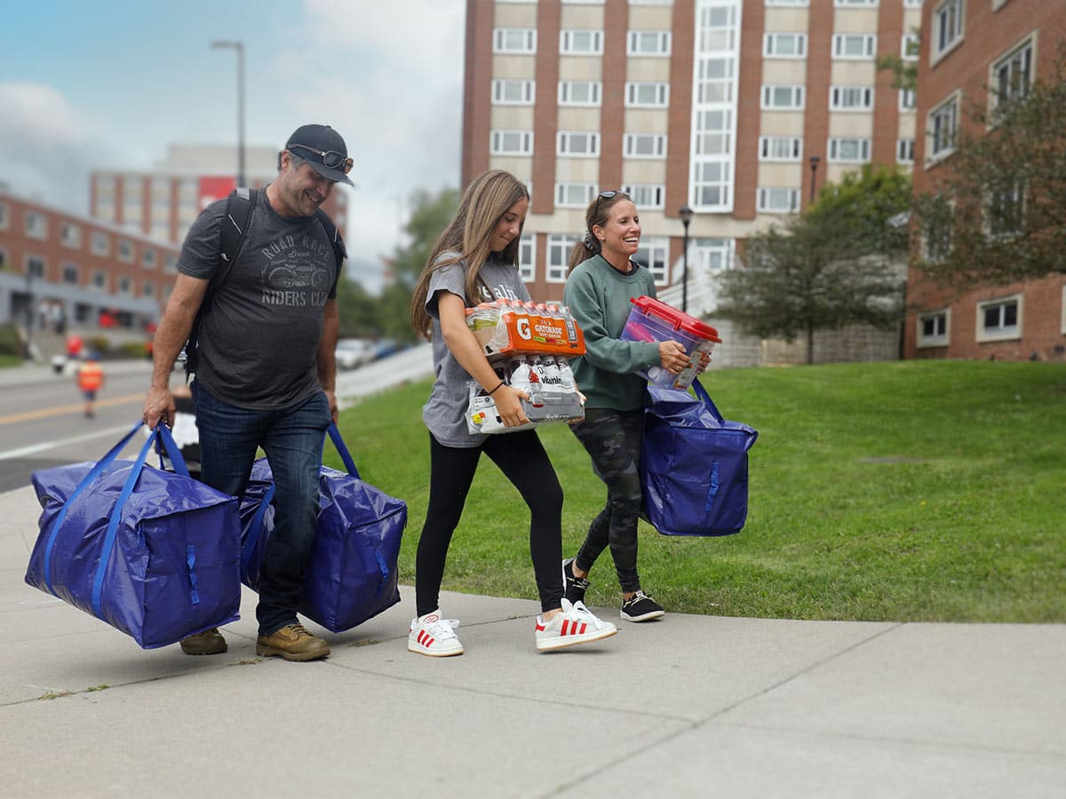 Parents helping carry their daughter's things to the residence hall on move-in day