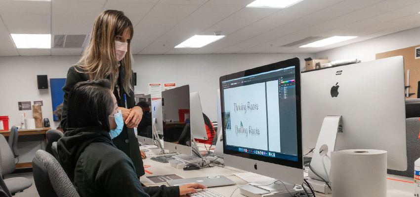 Instructor and a student discussing a project during a graphic design class