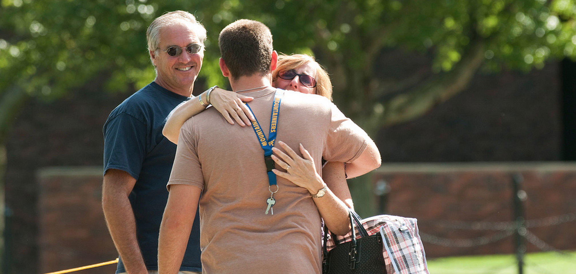 Parents hugging their son