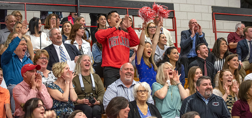 Family and friends cheer from the stands of the Park Center Ice Arena