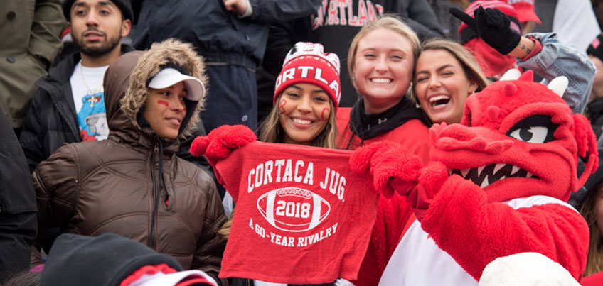 Blaze and SUNY Cortland students hold up a cloth banner that reads 