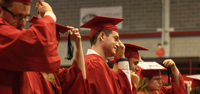 Students at commencement moving the tassels on their caps