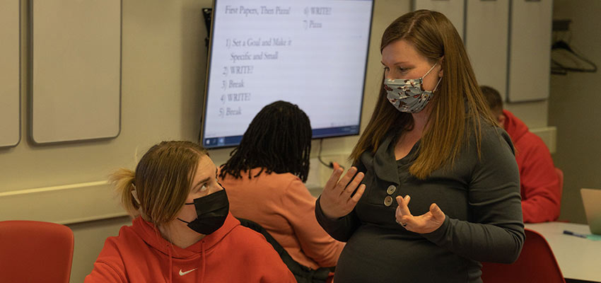 Student receiving instruction from a librarian during the Pizza and Papers event.