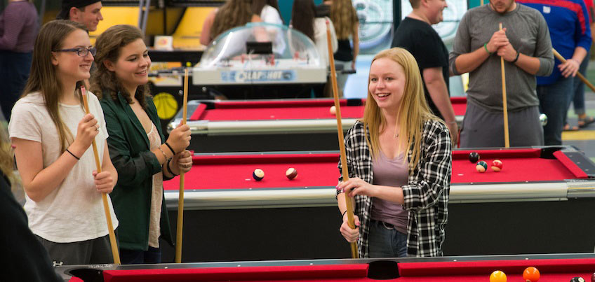 Students playing billiards in Game Room