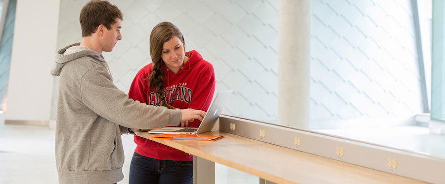 Two students looking at a computer together