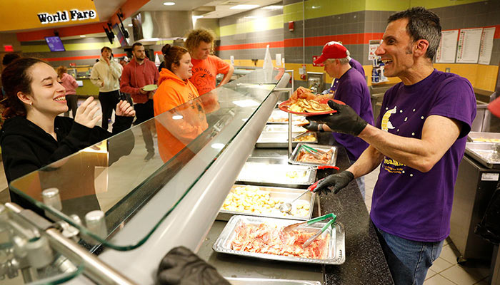 Faculty and staff serving students during finals week at Moonlight Breakfast