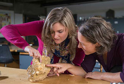 Professor and student studying the features of a rock.