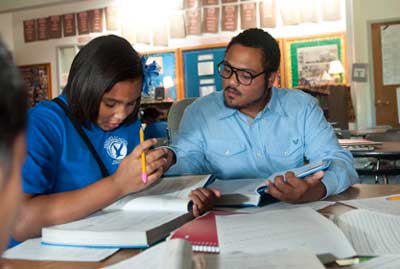 Social studies student teacher helping young students