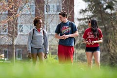 Three students walking together on campus.